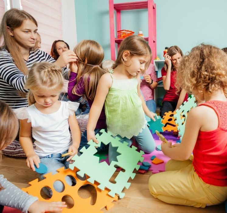 Groupe de parents et d'enfants en interaction lors d'une séance du programme "J'apprends en famille" chez Pluri-elles, Winnipeg.