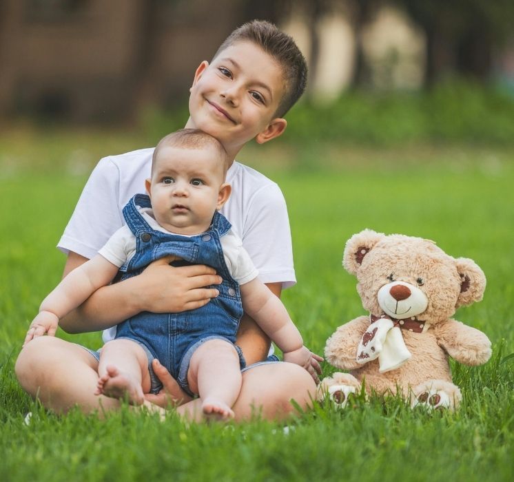 Élèves observant avec bienveillance un bébé lors d'une séance du programme "Racines de l'empathie" en salle de classe chez Pluri-elles, Winnipeg.