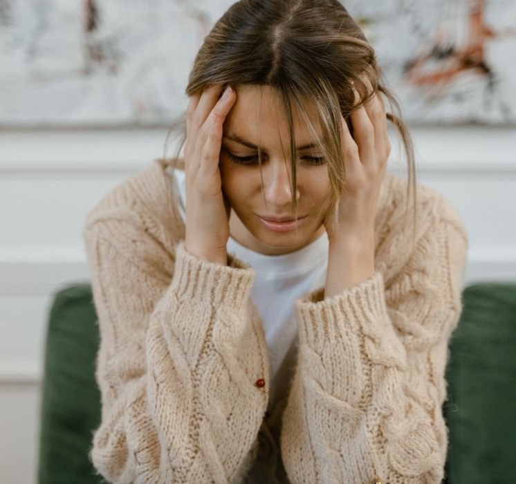 Fille pensive se tenant la tête, exprimant la détresse ou la réflexion, pour l'atelier de sensibilisation contre la violence chez Pluri-elles.