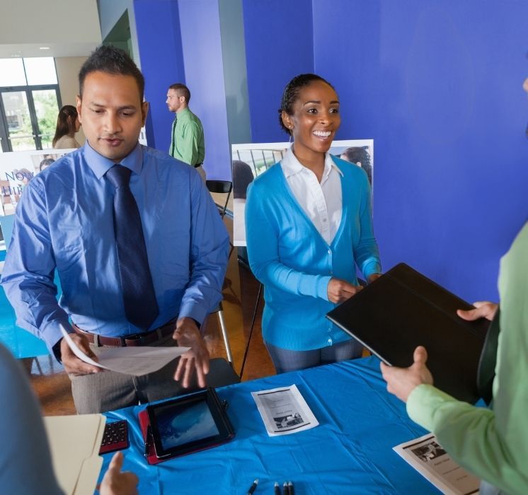 Candidats francophones et employeurs en discussion lors d'une foire d'emploi bilingue organisée par Pluri-elles à Winnipeg.