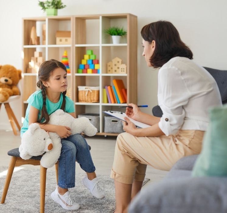 Une intervenante de Pluri-elles discute avec une enfant pour un atelier de résolution de conflits par la communication.