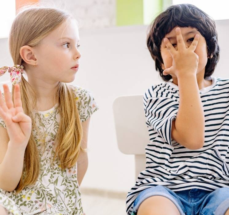Deux enfants en discussion animée illustrant la résolution de conflits et l'apprentissage de relations saines lors d'un atelier Pluri-elles.